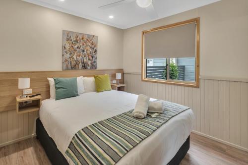 Un dormitorio con una cama grande y una ventana en Ingenia Holidays Lake Macquarie, en Mannering Park