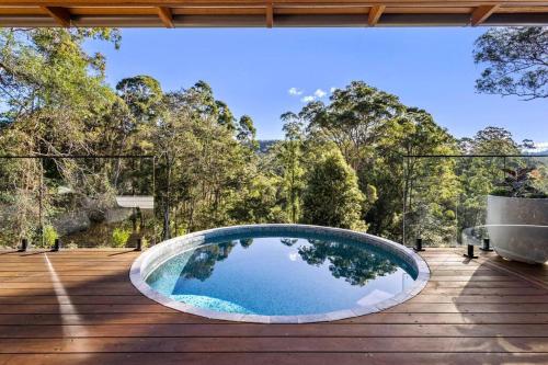 a circular pool on a deck with trees in the background at Pool House Bellingen in Fernmount