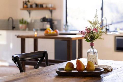 a table with a bottle and a plate with pears on it at Pool House Bellingen in Fernmount