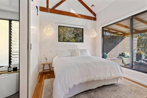 A bed or beds in a room at Pool House Bellingen