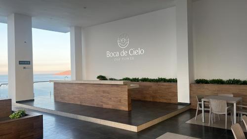a restaurant with a counter and chairs in a building at Malecón de Mazatlan Vista al mar Alberca Infinity Jacuzzi Gym in Mazatlán