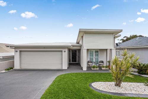 a house with a garage at Little Lake Beach House - Beachside 4 Bedroom Luxury Home in Lake Illawarra