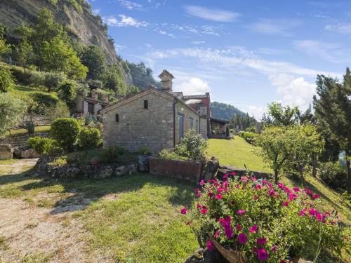 ein altes Steinhaus auf einem Feld mit Blumen in der Unterkunft Belvilla by OYO Santa Caterina in Monte San Martino