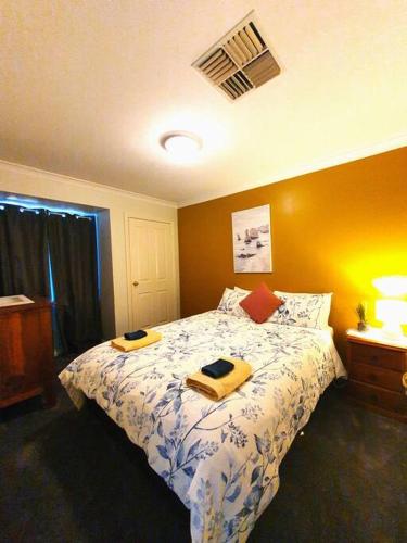 a bedroom with a bed with two towels on it at Adorable-secure 3 bedroom holiday home with Pool around the corner from The Miners Rest. in Kalgoorlie
