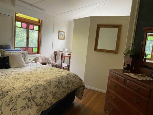 Schlafzimmer mit einem Bett, einer Kommode und Fenstern in der Unterkunft Wingham House in Wingham