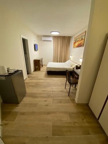 a hotel room with a bed and a desk at Berger Hotel in Tiberias