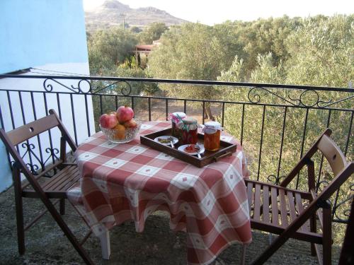 a table with a plate of fruit on a balcony at Diamanti Molivos Studios & Apartments in Mithymna