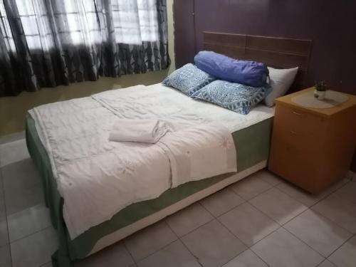 Una cama con dos almohadas encima. en RUMAH INAP BANDAR PERDANA, en Sungai Petani