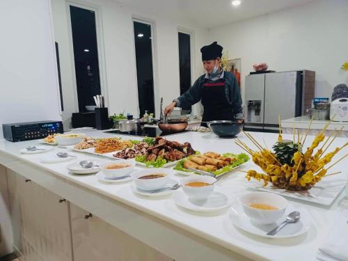a chef preparing food on a counter in a kitchen at Best world vision in Chaweng