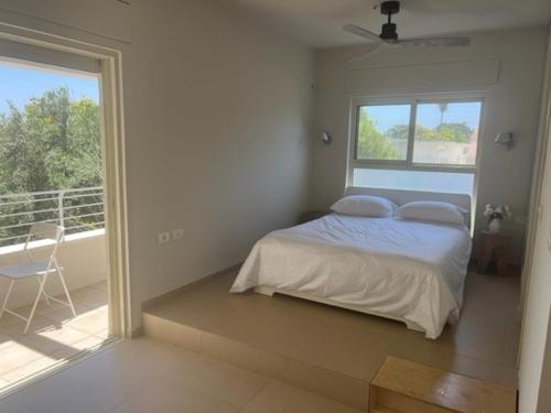ein Schlafzimmer mit einem Bett und einem großen Fenster in der Unterkunft שדות וים in Schawe Zion