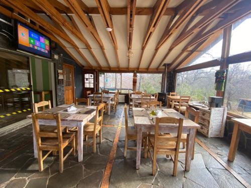 a dining room with wooden tables and chairs at HOTEL BOUTIQUE ANTTUY - Snow Spa in Chillán