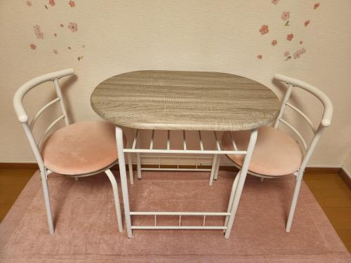 a table and two chairs sitting next to a table at Takaraboshi room 301 Sannomiya 10 min in Kobe