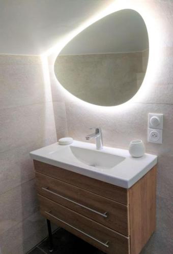 une salle de bain avec un lavabo et un miroir dans l'établissement Appart lumineux historique de Bayonne Saint-Esprit, à Bayonne