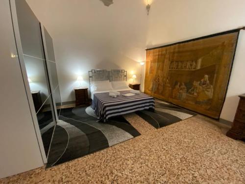 a bedroom with a bed and a large painting on the wall at Villa Guinigi Dimora di Epoca Exclusive Residence & Pool in Lucca