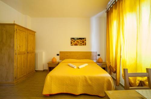 a bedroom with a yellow bed with two white towels at I Due Orfici in Cona
