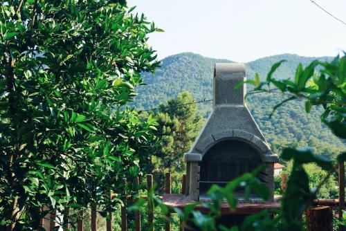 un petit bâtiment avec une montagne en arrière-plan dans l'établissement Geniş Bahçeli Barbekülü Kır Evi KOZALAK EVLERİ, à Ortaca