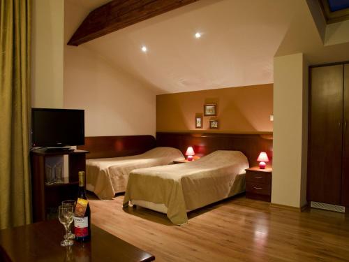 a hotel room with two beds and a flat screen tv at Bizev Hotel in Bansko