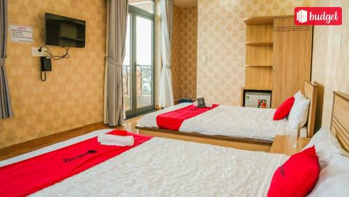 a hotel room with two beds with red sheets at Bich Thu Hotel in Ho Chi Minh City