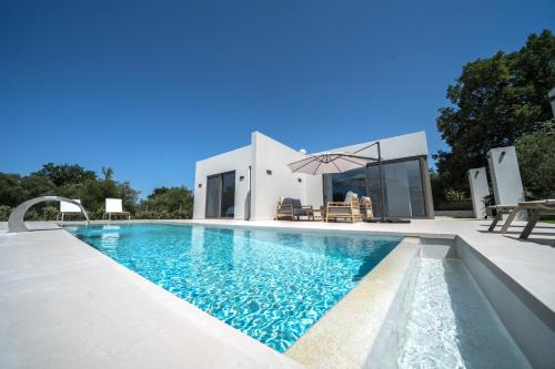 a swimming pool in front of a house at Villa Vivian Heated Private Swimming Pool & Jacuzzi in Georgioupolis