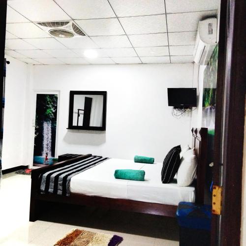 a bedroom with a bed and a tv in it at Lake Front Yala Safari in Kataragama