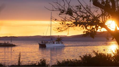 a boat floating in the water at sunset at Mariners One 1 at 39 Victoria Parade in Nelson Bay