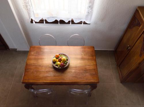 a bowl of fruit sitting on a wooden table at 4Elies apartments in Vourvourou