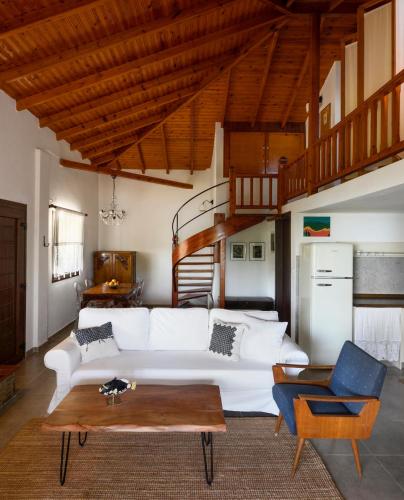 a living room with a white couch and a table at 4Elies apartments in Vourvourou
