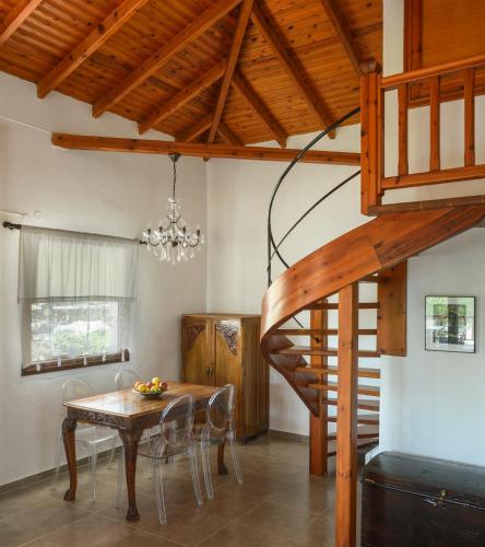 a dining room with a table and a staircase at 4Elies apartments in Vourvourou