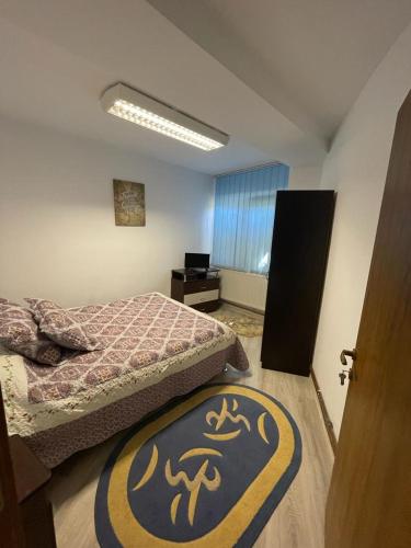 a room with two beds and a rug on the floor at Apartament Mioritza 2B in Horezu