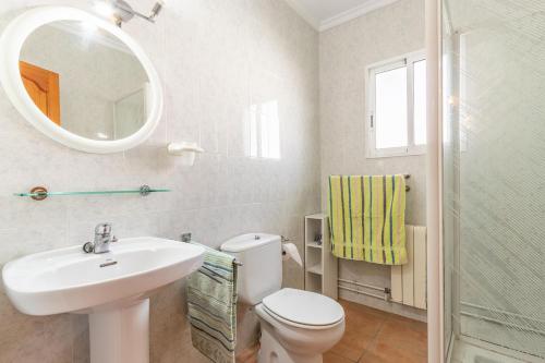 a bathroom with a sink and a toilet and a mirror at Spacious family home with Airco, private 5x10m pool, sandy beach 300m, free WiFi in Denia