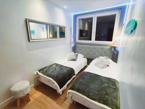 a room with two beds and a window at BALNEO 100M PLAGE JARDIN BRASERO in Berck-sur-Mer