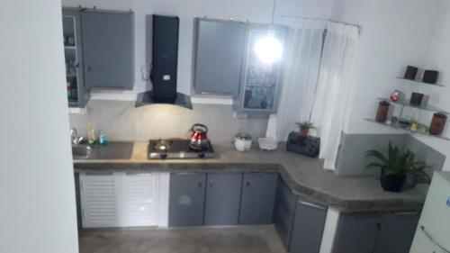 a kitchen with a sink and a counter top at Jal,Min Homestay in Kandy