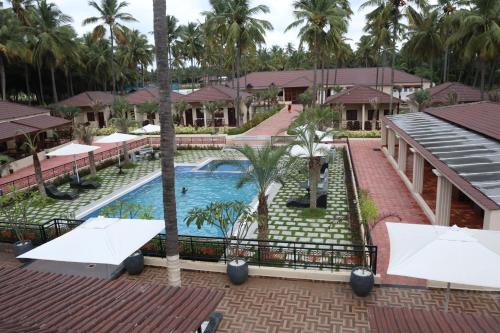 an aerial view of a resort pool with palm trees at Royal Destiny Resort in Malaiyāndipattanam