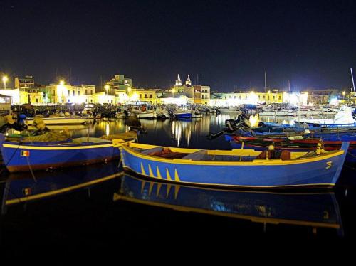 a group of boats docked in a harbor at night at Vien dal Mare in Bari