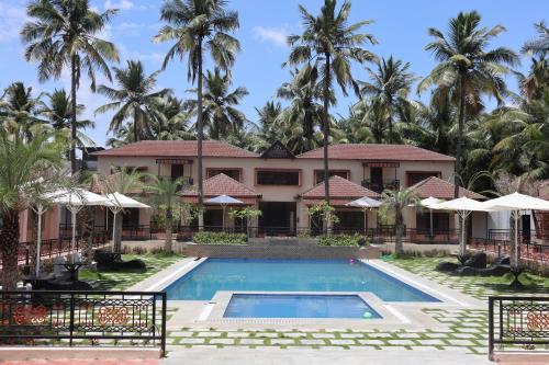 a view of a resort with a swimming pool and palm trees at Royal Destiny Resort in Malaiyāndipattanam