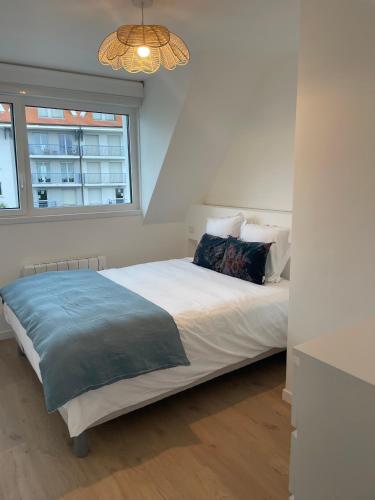 une chambre avec un grand lit avec une fenêtre dans l'établissement Villa Poirabelle, à Wimereux