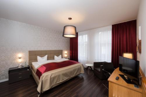 a hotel room with a bed and a television at Hotel Südlohner Hof - Ristorante Da Fabio in Südlohn