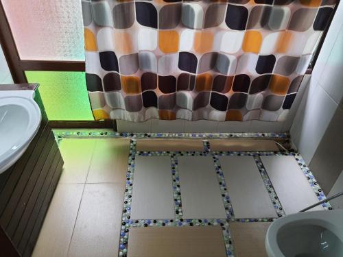 a bathroom with a shower curtain and a sink at T Star Cottage Langkawi in Pantai Cenang