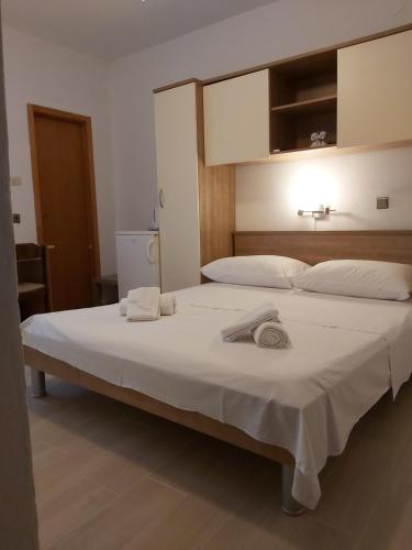 ein großes weißes Bett mit zwei Handtüchern darauf in der Unterkunft B&B Sobe Magdalena in Metajna