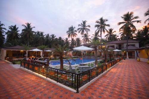 a resort with a swimming pool and palm trees at Royal Destiny Resort in Malaiyāndipattanam