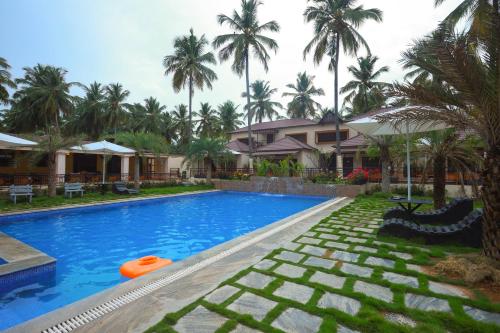 a swimming pool with a frisbee next to a house at Royal Destiny Resort in Malaiyāndipattanam
