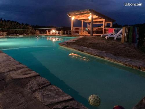 uma piscina à noite com um gazebo em Granal em Saint-Julien-Gaulène