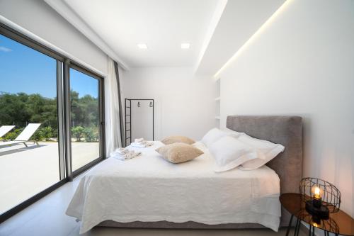 a bedroom with a bed and a large window at Villa Vivian Heated Private Swimming Pool & Jacuzzi in Georgioupolis
