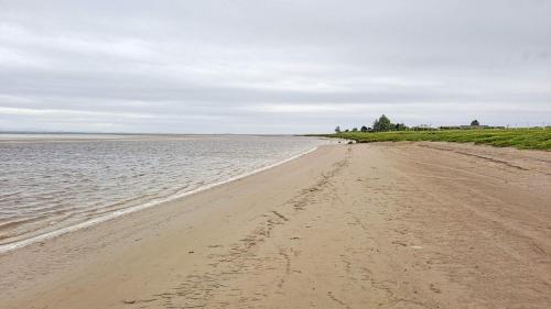 a sandy beach with footprints in the water at Gretna Getaway in Gretna
