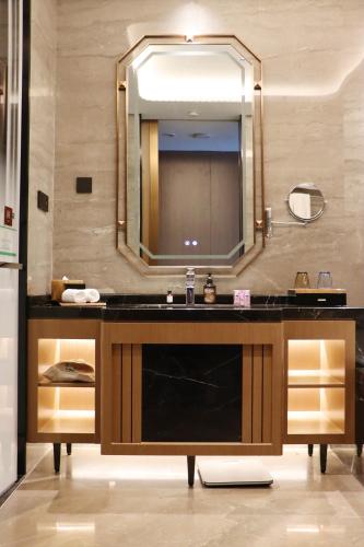 a bathroom with a sink and a mirror at La Quinta by Wyndham Weifang South in Weifang