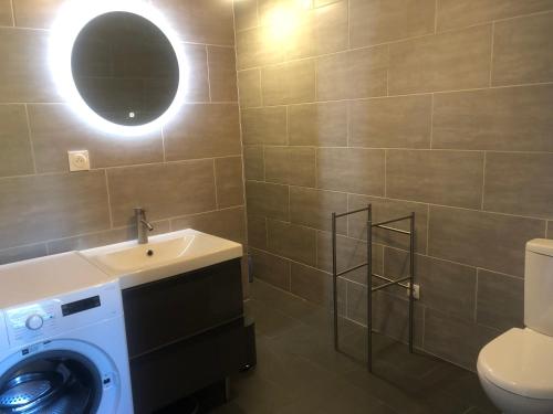 a bathroom with a washing machine and a sink at Le Rucher in Bois-Normand-près-Lyre