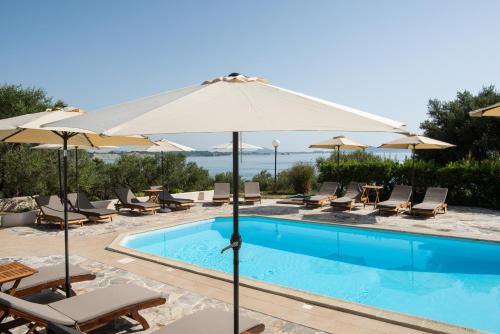 a swimming pool with chairs and umbrellas next to a resort at Villa Flisvos in Marathias