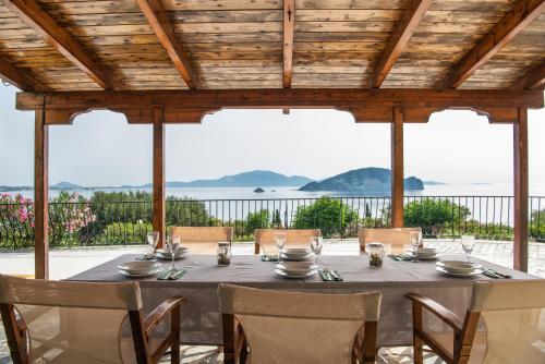a table on a patio with a view of the ocean at Villa Flisvos in Marathias