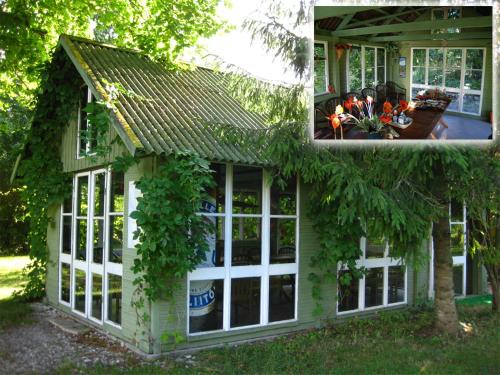 una casa con ventanas y flores en el patio en Kusti Turismitalu, en Vilsandi