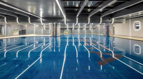 an indoor swimming pool with blue tile floor and blue water at Shenzhenair International Hotel in Shenzhen